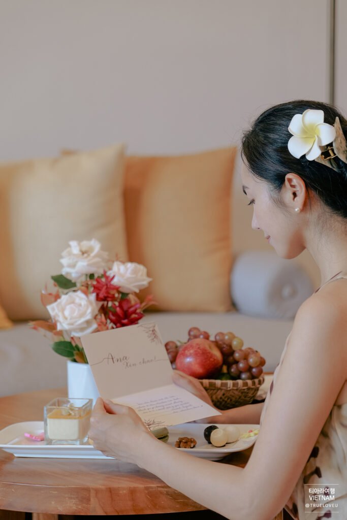 Woman reading a welcome card beside a fruit platter at Ana Mandara resort in Nha Trang, Vietnam