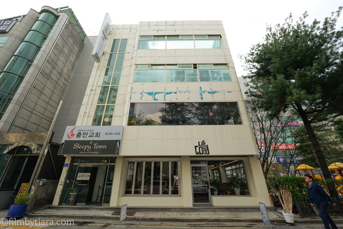 Cream-colored building exterior with the Sleepy Town cafe sign above the entrance in Dunsan-dong, Daejeon