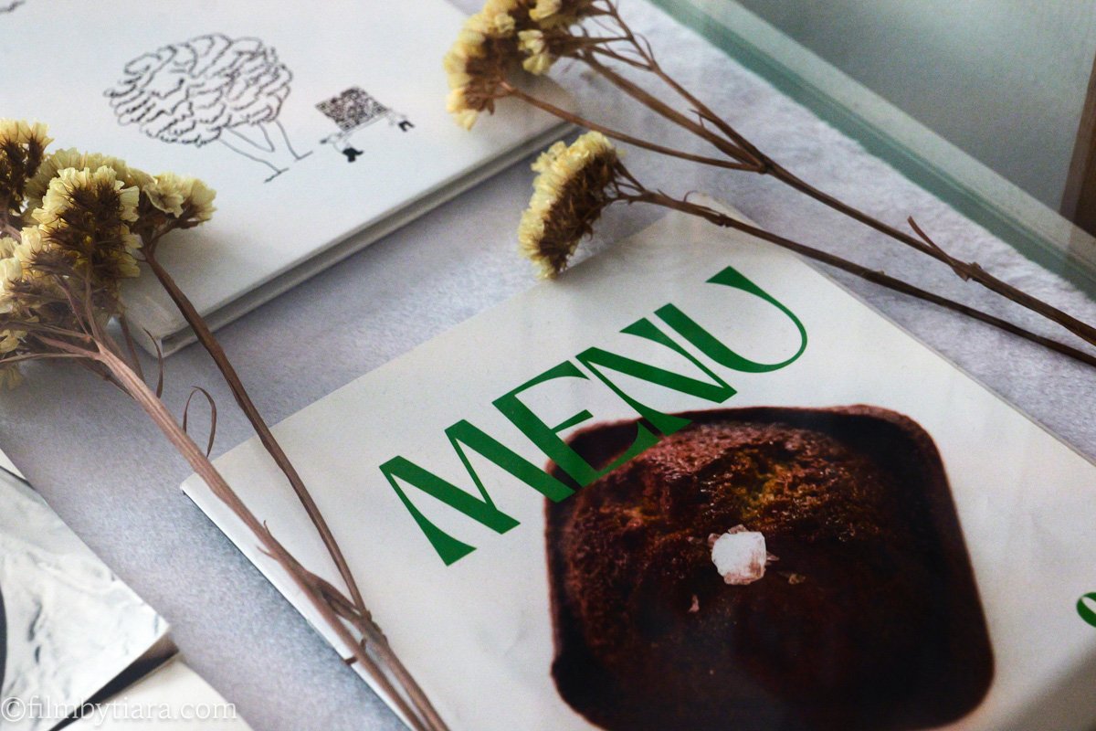 Small menu booklets styled with dried flowers on a table at Sleepy Town cafe