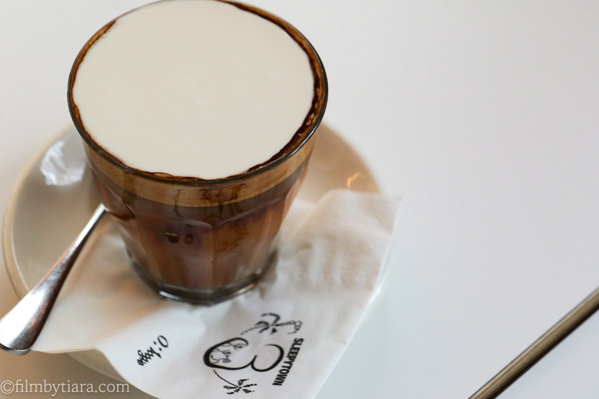 Close-up of a butterscotch cream coffee in a glass on a branded Sleepy Town napkin