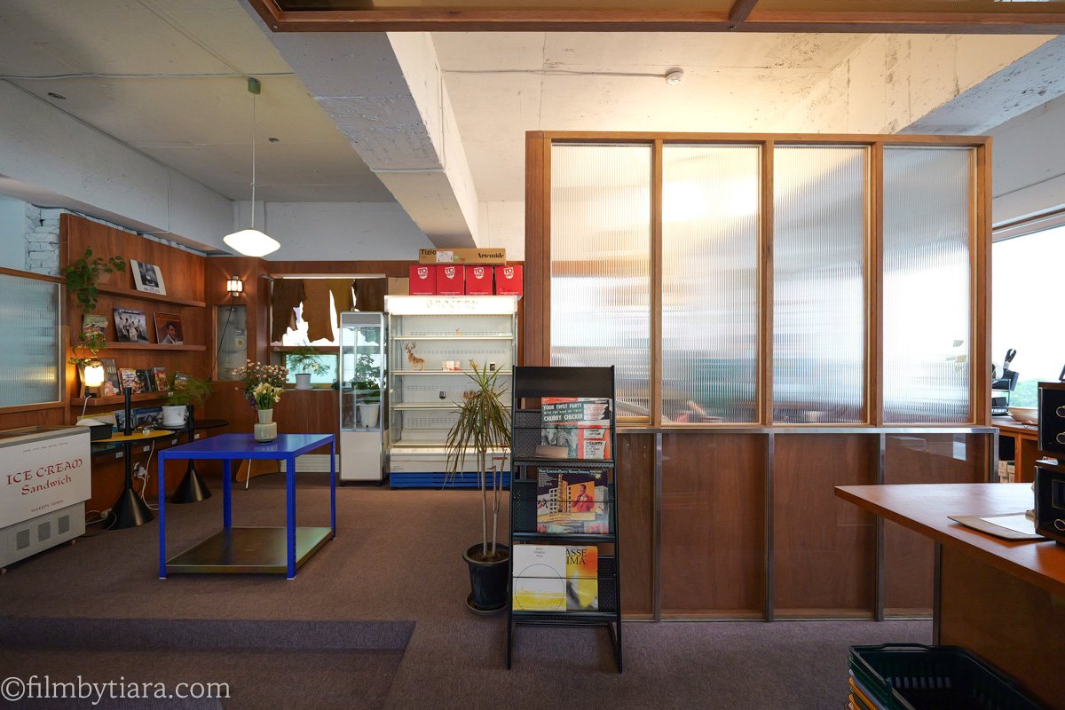 Wood-paneled cafe corner with a frosted glass partition and an ice cream sandwich freezer