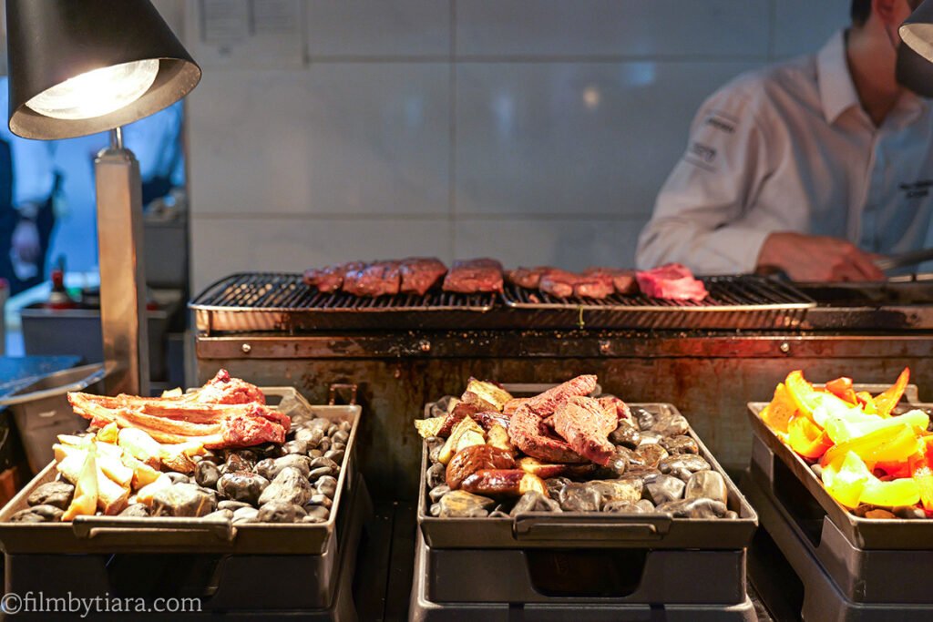 Chef grilling steak at the live station in La Palette Paris buffet