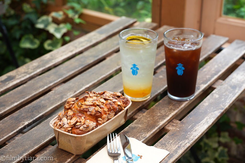 Iced drinks and a bakery pastry served on a wooden table at The Fore