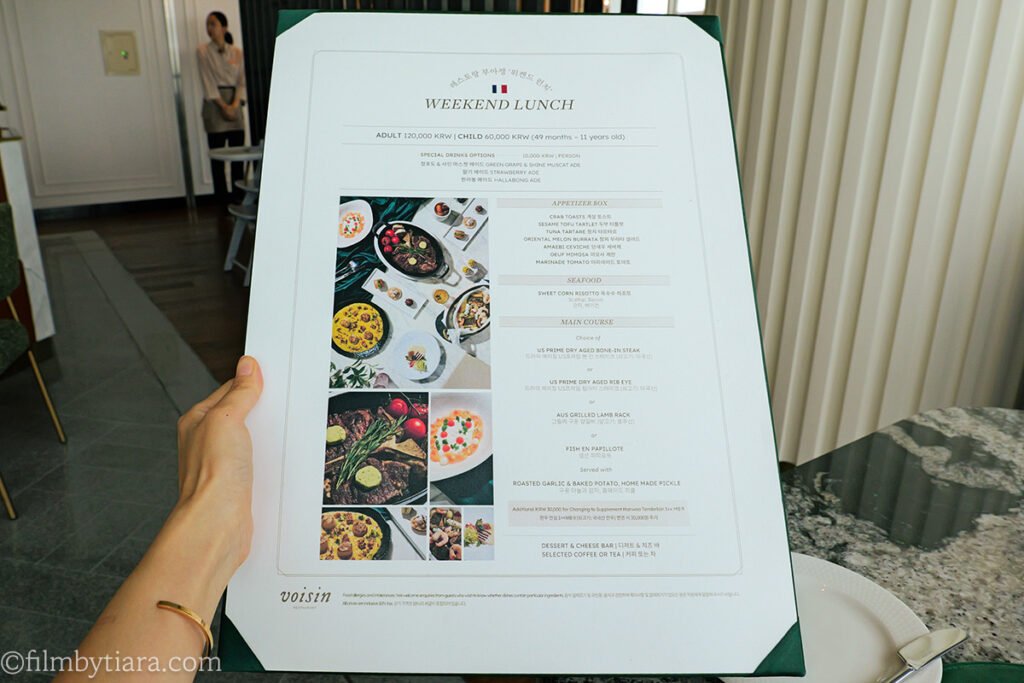 Hand holding the Hotel Naru seoul Restaurant Voisin weekend lunch menu card