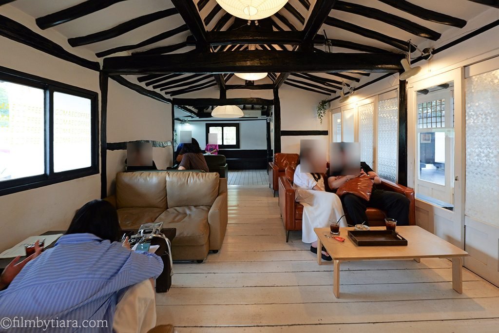 Cozy indoor lounge area with leather sofa and warm lighting at Gomae Coffee