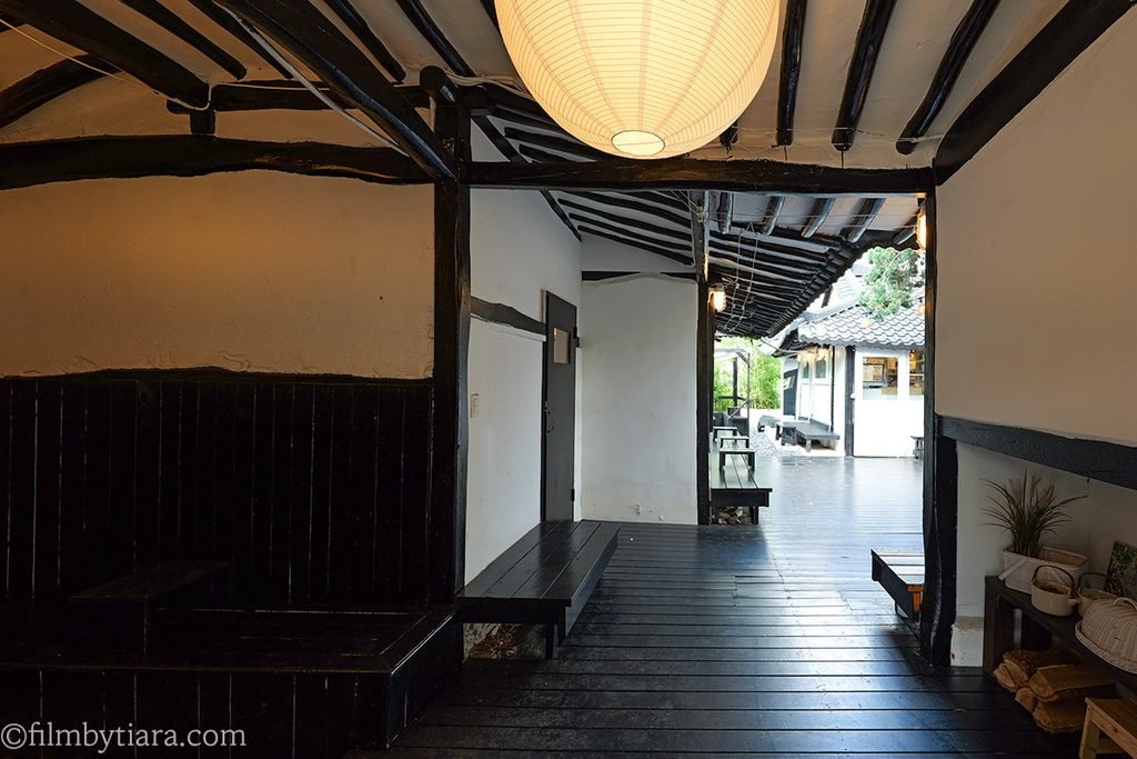 Interior view of Gomae Coffee hanok hallway featuring wooden rafters and rafters