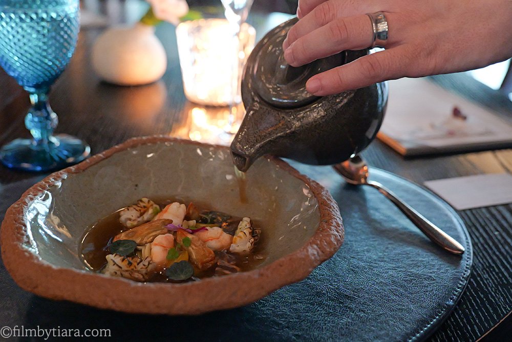 Pouring shrimp consommé over squid tataki at Mariposa at Fairmont Seoul