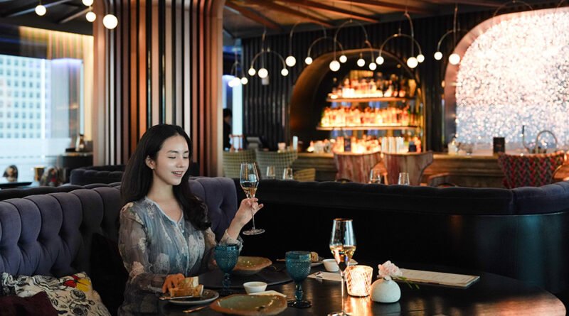 A woman with a red clutch purse, a blogger, is seated for dinner at Mariposa at Fairmont Seoul.